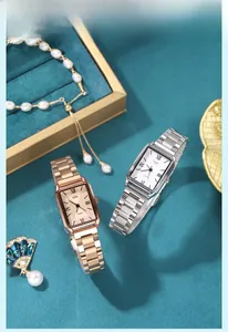 Detail of classic square quartz watches in rose gold and silver on velvet with pearls