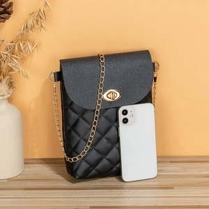 Mini borsa trapuntata nera per cellulare con catena dorata su superficie in legno