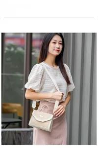 Photo mannequin d'un sac à main en paille tissée avec bordure crème et bandoulière
