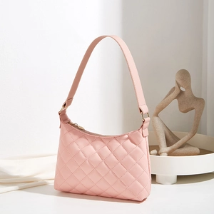 Pink quilted faux leather underarm bag with gold zipper on a minimalist background