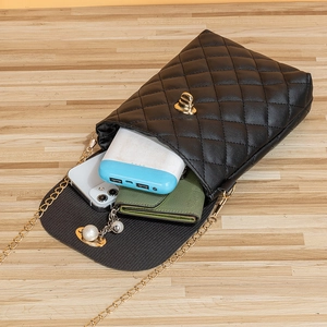 Mini borsa trapuntata nera con catena dorata e ciondolo di perle, vista sulla capienza interna