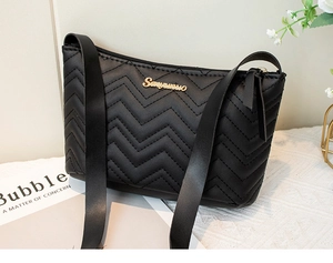Close-up of black quilted V-pattern shoulder bag with golden logo and zipper details