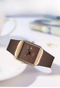 Detail of square rose gold quartz watch with brown strap and small calendar window