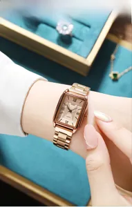Close-up of a women's rose gold square watch featuring a sunray dial and metal steel strap