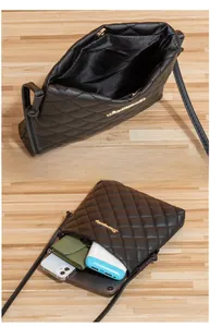 Detail of black quilted crossbody bag showing internal storage for phone and power bank