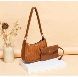 Detail of brown quilted leather shoulder bag and matching pouch on geometric display