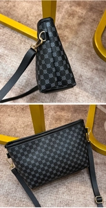 Detail view of black pebble leather handbag featuring grey geometric floral print and gold hardware