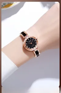 Detail of GEDI rose gold quartz watch featuring a black dial and diamond hour markers