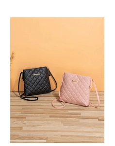 Detail shot of black and pink crossbody bags with diamond quilted texture and gold logo
