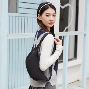 Minimalist black crescent crossbody bag in durable nylon with adjustable shoulder strap