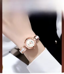 Close-up of rose gold quartz watch with rhinestone markers and ceramic link bracelet