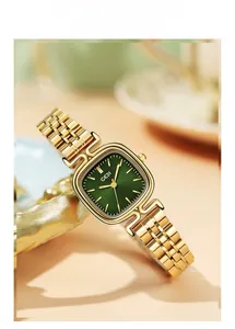 Detail of square gold watch with sunray green dial and metal link bracelet
