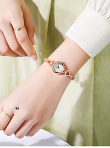 Close-up of rose gold watch featuring hollow heart-shaped links and diamond-set bracelet