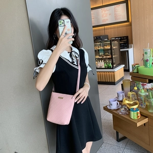 Pink minimalist bucket handbag with textured synthetic leather and golden metal plate