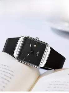 Close-up of elegant square quartz watch with black dial and silver case on a book