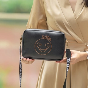 Black square shoulder bag with orange pumpkin embroidery and printed wide strap