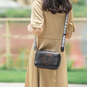 Fashionable black crossbody bag with orange pumpkin embroidery and wide woven strap