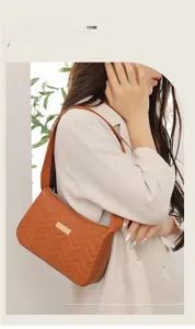 Brown faux leather underarm bag with elegant herringbone stitching and gold plate accent