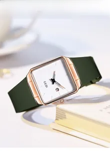 Detail of square rose gold watch with deep green strap and date window display