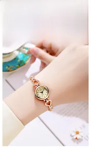 Close-up of rose gold watch featuring heart-shaped hollow links and subtle rhinestone inlay