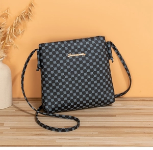 Detail of crossbody bag with Sunniyoilly gold logo and geometric floral pattern