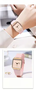 Detail of pink silicone watch with rose gold square case and date display feature