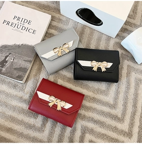 Détail à plat de trois mini portefeuilles en similicuir en gris, noir et bordeaux élégant