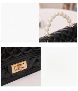 Detail of white pearl handle and golden twist lock on black quilted jelly handbag