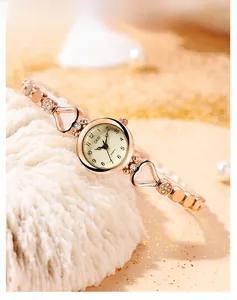 Close-up of rose gold quartz watch with heart-shaped hollow metal bracelet and crystals