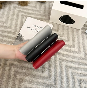 Vue détaillée des porte-cartes en cuir texturé gris, noir et rouge avec boucles métalliques