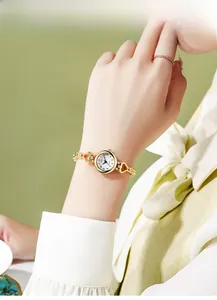 Close-up of gold alloy ladies watch featuring heart-shaped links and rhinestone accents