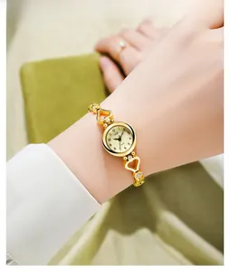 Detail of GEDI gold quartz watch with rhinestone heart bracelet and round numeric dial