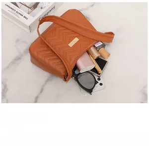 Top view of open tan chevron stitched underarm bag showing spacious interior with essentials