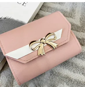Vue détaillée du portefeuille rose en cuir synthétique avec boucle dorée élégante