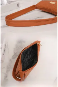 Detail of caramel PU leather bag with V-shaped quilting, reinforced strap and zip closure