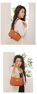 Detailed view of caramel brown quilted underarm bag with V-shaped stitching and gold plaque