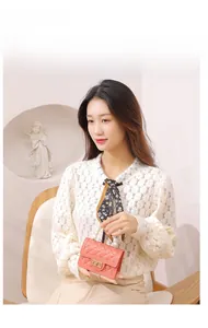 Pink quilted mini jelly bag with pearl handle and golden twist lock on a female model