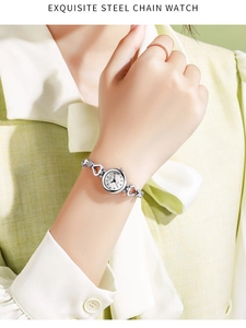 Close-up of OKSI ladies steel watch with silver heart-shaped bracelet links on wrist