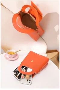 Mini sac Boston orange avec poignée ronde montrant l'espace de rangement intérieur