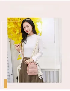 Pink mini faux leather backpack shown with magnetic buckle pocket and metal logo detail