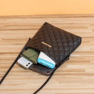 Quilted black crossbody bag for women showing interior space for tablet and smartphone