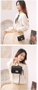 Detail of black quilted mini jelly bag with white pearl handle and gold chain strap