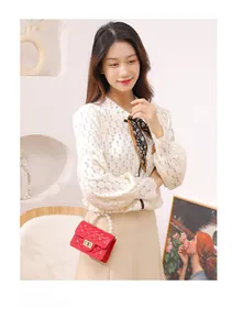 Detail of red quilted mini jelly bag with pearl handle and gold chain strap