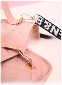 Detail of pink quilted handbag showing gold metal hook and magnetic closure buckle