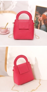 Détail du mini sac Boston rose rouge avec chaîne dorée et poignée ronde élégante