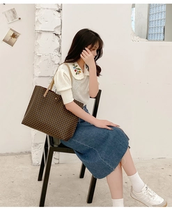 Close-up of vintage tote bag featuring classic geometric monogram and leather straps