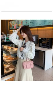 Pink quilted square handbag with floral embroidery and wide patterned fabric strap