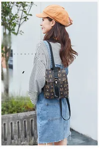 Close-up of printed leather backpack with drawstring closure and buckle detail on a model