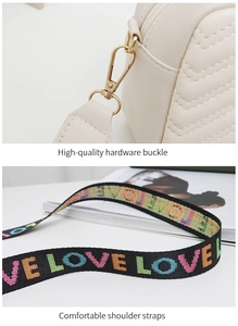 Macro shot of high-quality gold hardware buckle and 'LOVE' embroidered strap details
