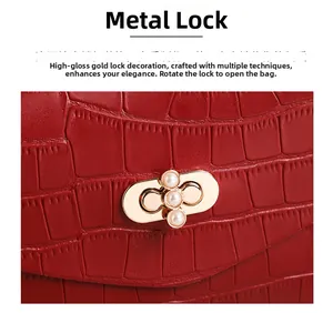 Detail of red croc-embossed bag featuring a gold twist lock with three pearl accents